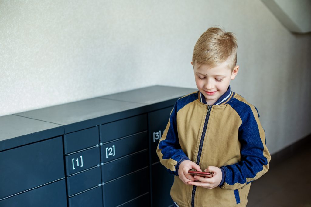 Boy client using automated self service post terminal machine or locker. Mail shipping concept